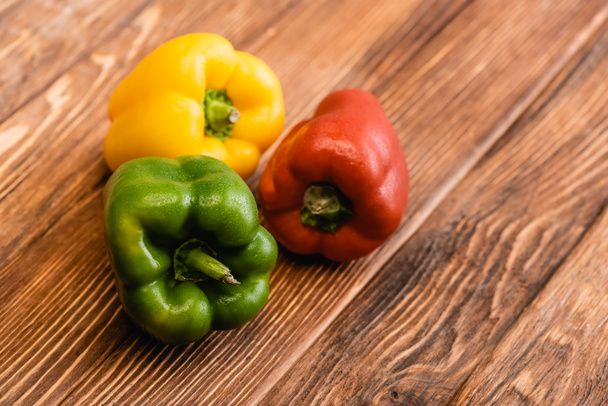 colorful ripe bell peppers on wooden table - Valokuva, kuva
