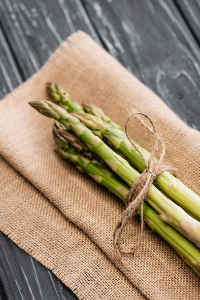 fresh green asparagus on burlap on wooden surface - Foto, imagen