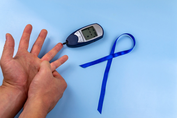 De mens meet bloedsuikerspiegel met elektronische glucometer Wereld Diabetes Dag - Foto, afbeelding