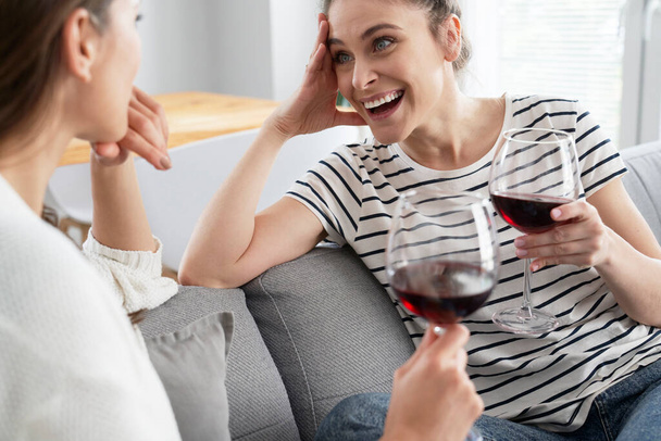 Glückliche Freunde sitzen bei einem Glas Wein                                 - Foto, Bild