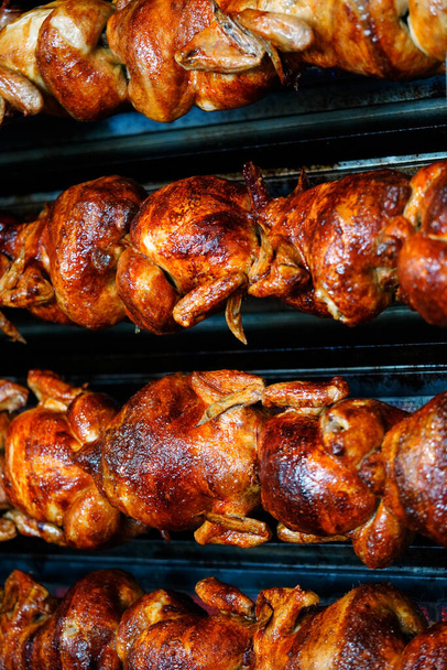      Filas de pollos enteros asados tostados calientes, en España - Foto, imagen