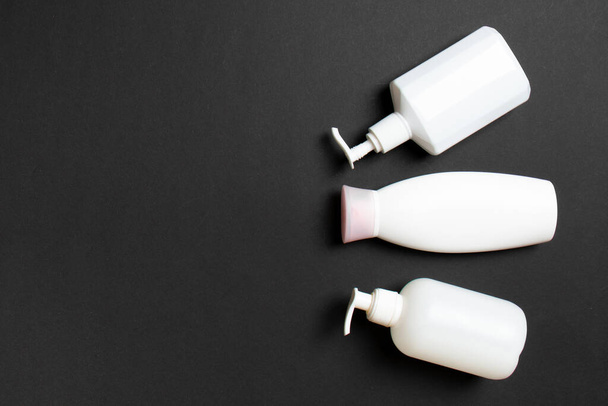 Set von weißen Kosmetikbehältern isoliert auf farbigem Hintergrund, Draufsicht mit Kopierraum. Gruppe von Plastikflaschenbehältern für Körperpflege mit Leerraum für Ihr Design. - Foto, Bild
