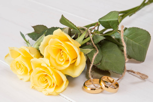 Yellow roses and wedding rings tied with string - Φωτογραφία, εικόνα