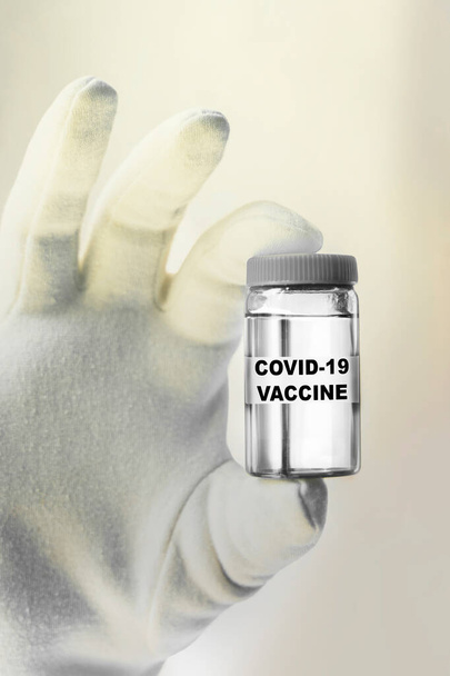 Εμβόλιο Covid-19 στο χέρι ενός επιστήμονα. εργαστηριακός σωλήνας που συγκρατεί το εμβόλιο του ιού nCoV Coronavirus για τον ιό 2019-nCoV COVID, vetical image - Φωτογραφία, εικόνα