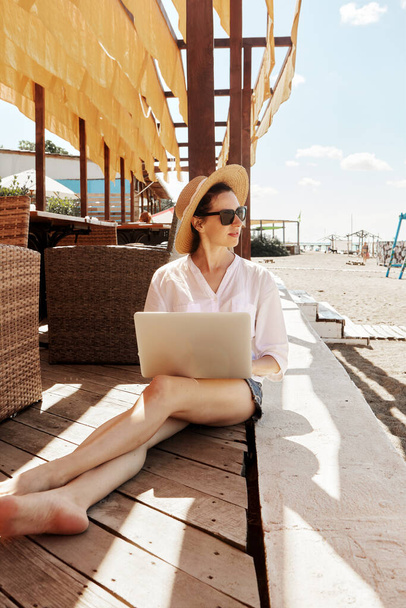 Молода жінка використовує ноутбук на пляжі. Концепція позаштатної роботи
 - Фото, зображення