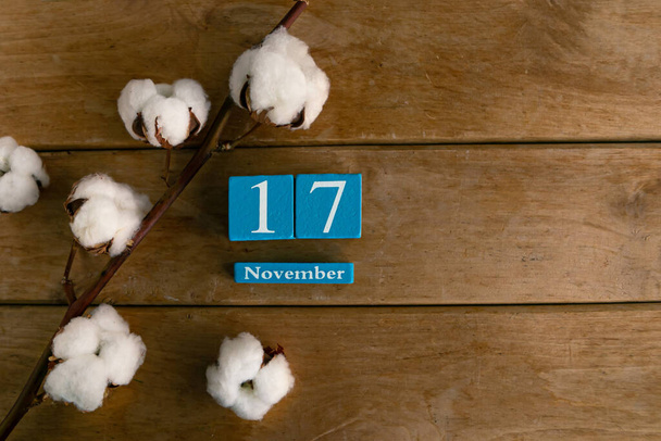 November 17th. Blue cube calendar with month and date on wooden background. - Photo, Image