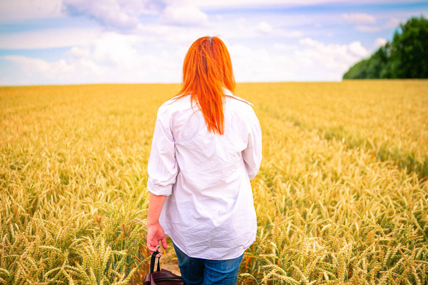 young woman in countryside road through wheat field, summer background - Fotografie, Obrázek