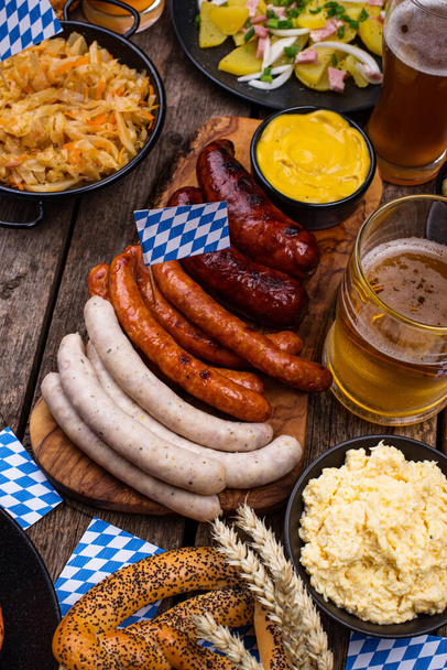 Oktoberfest dishes with beer, pretzel and sausage - Foto, afbeelding