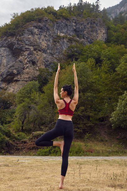 Lezioni di yoga in natura. Il concetto di fare sport da solo. Esclusione sociale. Una donna fa yoga in montagna - Foto, immagini
