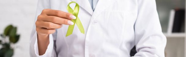 cropped view of doctor holding green awareness ribbon, mental health concept, website header - Foto, Imagem