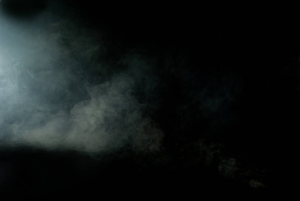 White smoke on a black background. Colored smoke with a blue tinge. The texture of scattered smoke. Blank for design. Layout for collages. - 写真・画像