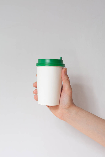 Αφαιρέστε το φόντο της κούπας καφέ. Αρσενικό χέρι κρατώντας ένα φλιτζάνι καφέ χαρτί  - Φωτογραφία, εικόνα