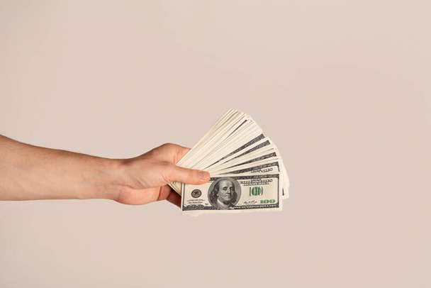 Closeup of successful guy holding US money on light background - Foto, imagen
