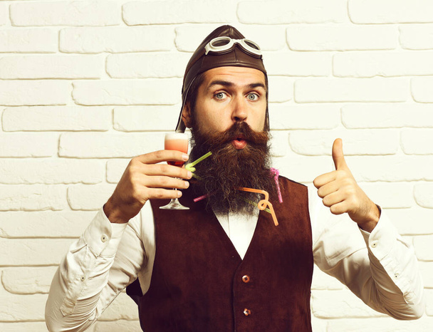 surprised handsome bearded pilot on white brick wall background - 写真・画像