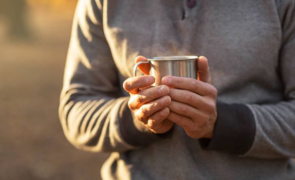Male hands holding warm cup of tea or coffee - Foto, imagen
