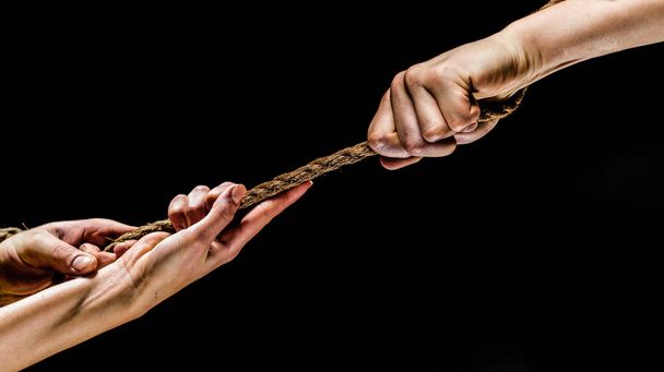 Conflict, tug-of-war, rope. Hand holding a rope, climbing rope, strength and determination concept. Safety. Macro shot isolated over black background. - Fotó, kép