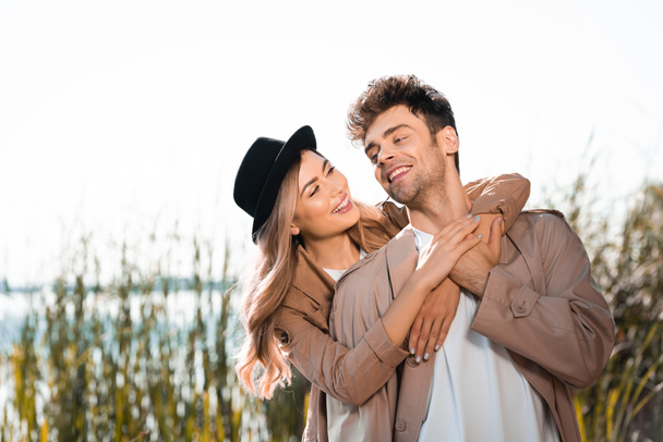 blonde woman in hat and man embracing outside - Photo, Image