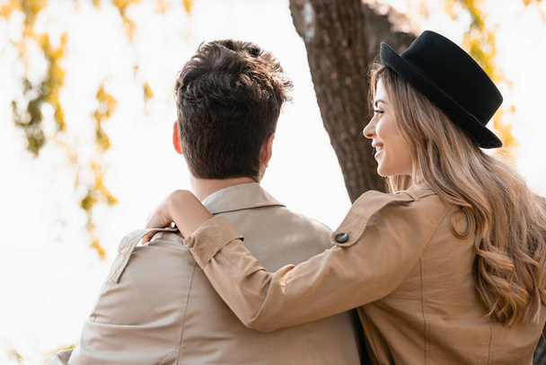 blonde woman in hat touching and looking at boyfriend outside - Photo, Image