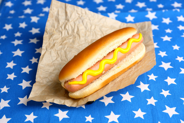 Tasty hot dog on napkin with stars, isolated on white - Photo, Image