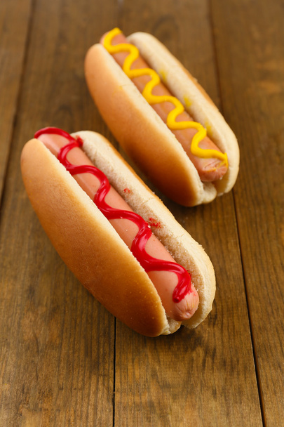 Tasty hot dogs on wooden table - Fotó, kép