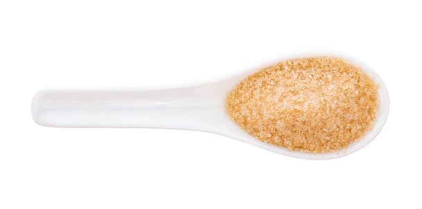 Bruine suiker in lepel op witte achtergrond - Foto, afbeelding