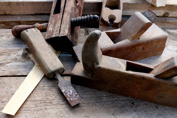 Old wooden carpenter's planes on a wooden background. Still life with old carpenter's planes - Photo, Image