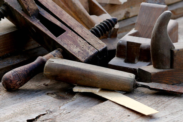 Old wooden carpenter's planes on a wooden background. Still life with old carpenter's planes - Photo, Image