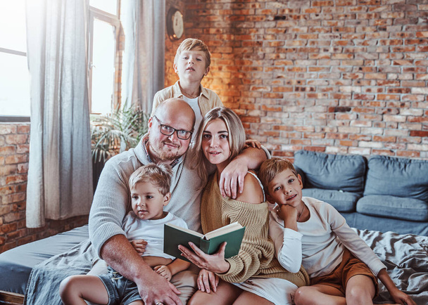 Rodiče učí své děti číst v obývacím pokoji - Fotografie, Obrázek
