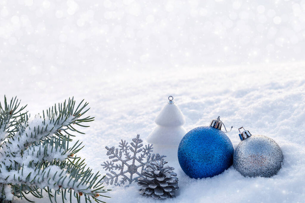Голубые рождественские украшения на снегу. - Фото, изображение