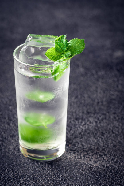 Glass of mojito cocktail on dark background - Photo, Image