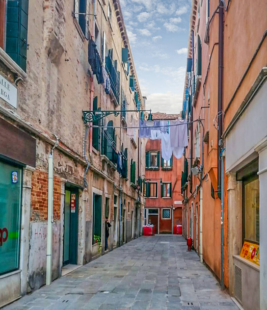 un tipico vicolo nel centro storico di Venezia con stendibiancheria tra le case colorate - Foto, immagini