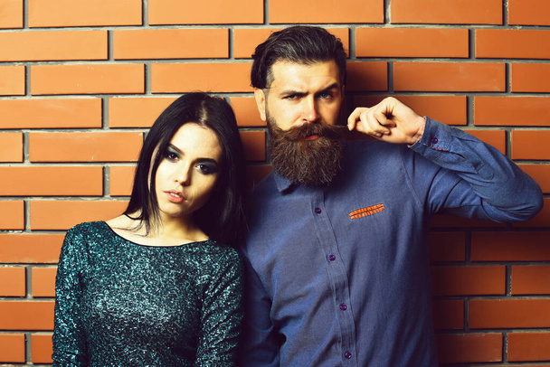 bearded man and pretty sexy woman on brick wall - Фото, зображення