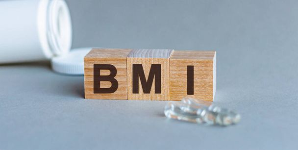 Gri arkaplanda "Bmi" yazan tahta bloklar. vücut kütle indeksi tıp kavramı - Fotoğraf, Görsel