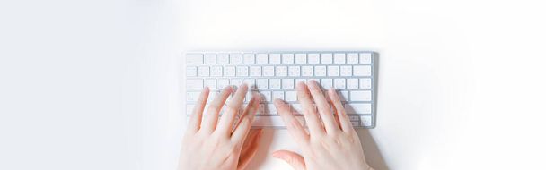 plat lay werk en online leren in een nieuw normaal concept van vrouw typen op draadloos toetsenbord met witte geïsoleerde achtergrond - Foto, afbeelding