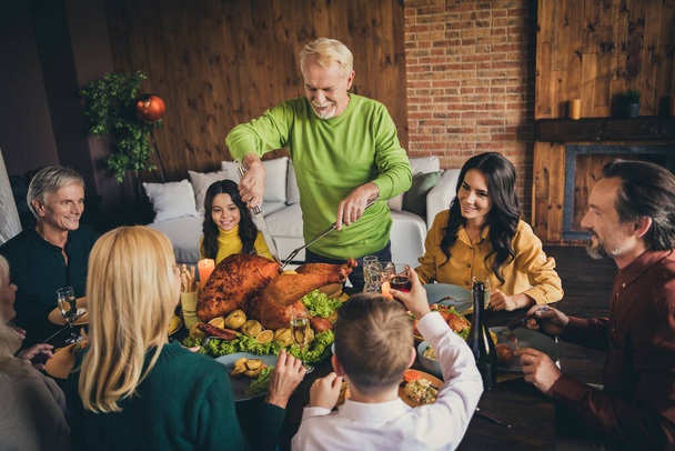 Portrait of nice adorable cheerful multinational family small little kids meeting cutting domestic turkey farm product harvest celebration at modern loft industrial brick interior house - Foto, Imagem