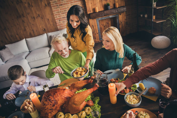 Above high angle view of nice attractive cheerful careful adorable family parents grandparents eating homemade turkey harvest serving nursery at modern loft brick industrial interior indoors - Фото, зображення