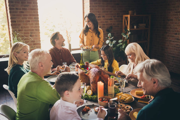 Portrait of nice attractive cheerful family parents grandparents multi generation sitting around served table eating homemade meal autumn custom at modern loft brick industrial interior house - Foto, afbeelding