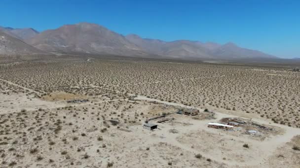Вид с воздуха на заброшенные дома и трейлер кемпера посреди пустыни - Кадры, видео