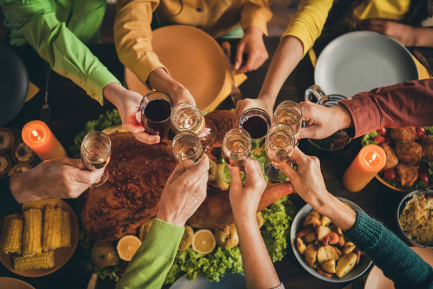 Cropped top above high angle view of hands friends friendship family parents sitting around served table clinking glasses celebratory time evening November custom tradition - Fotoğraf, Görsel