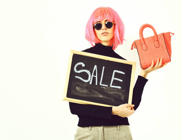 girl in wig holding bag and board with sale inscription - Фото, изображение