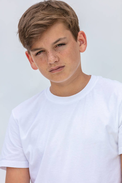 White background studio portrait of a boy teenager teen male child wearing a white t-shirt - Foto, imagen