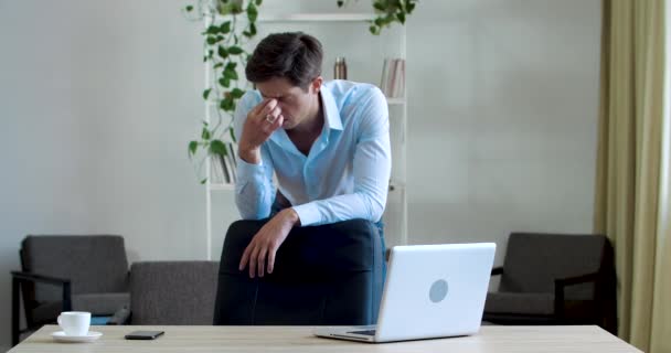 Uupunut väsynyt nuori aikuinen yritysjohtaja seisoo toimistokodissa, ajattelee harkitusti epäonnistumista, järkyttää, ratkaisee ongelman, hermostuu vaikeasta työstä, pitää leukaansa kädellä, ongelma-konsepti - Materiaali, video