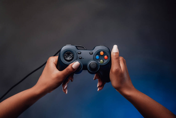Las mujeres de piel negra de la mano agarra el dispositivo de juego - Foto, imagen