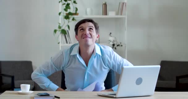 Happy business man sitting in office at home room at desk, throws pile of documents, scraps of paper notes flying in air, male feels joyful satisfaction, celebrating end of paperwork success concept - Footage, Video