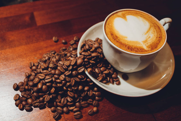 A cup of cappuccino with coffee bean as background. - Photo, image