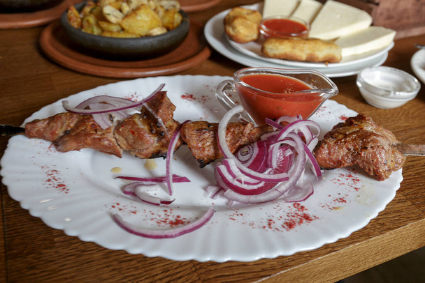 Meat, grilled on skewers, Pork with pickled onion, Shot of dinner in Restaurant. - Foto, afbeelding