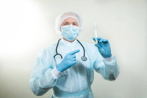 Egy orvosi maszkos orvos portréja. Van egy sztetoszkóp az orvos nyakán. Egy világjárvány idején a jogorvoslatok elengedhetetlenek. Fehér alapon elszigetelve. - Fotó, kép