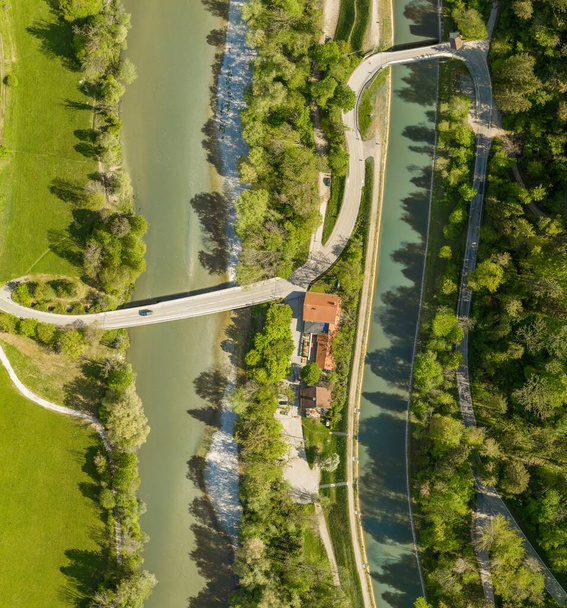 Vista superior desde un avión no tripulado en un coche de conducción en un puente sobre un río con un bosque nebuloso y una casa con una ranura de estacionamiento.. - Foto, imagen
