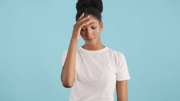 Portrait of sad african american girl showing face palm expression on camera over colorful background - Foto, Bild