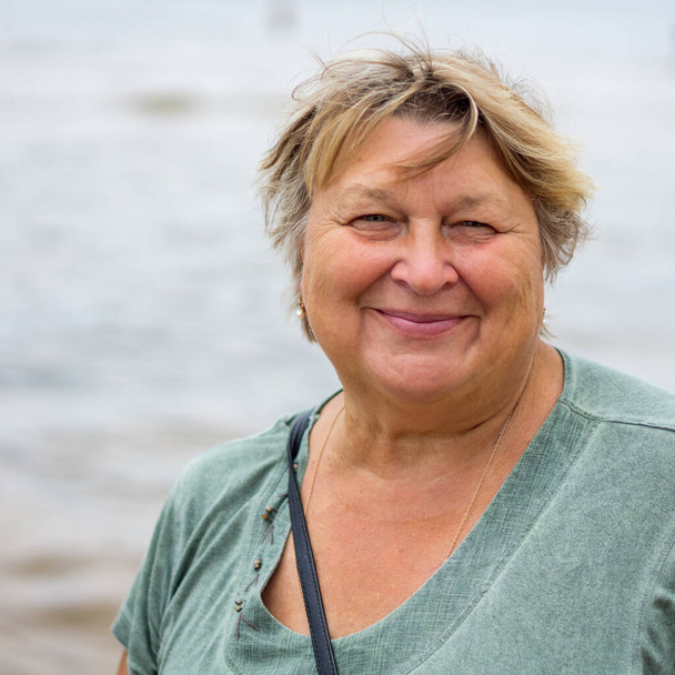Ώριμη παχουλή γυναίκα ξεκουράζεται στην παραλία της Βαλτικής Θάλασσας - Φωτογραφία, εικόνα